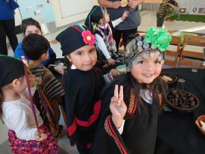Niñas de educación parvularia vestidas con trajes tradicionales mapuche participan en una celebración del Día Nacional de los Pueblos Indigenas